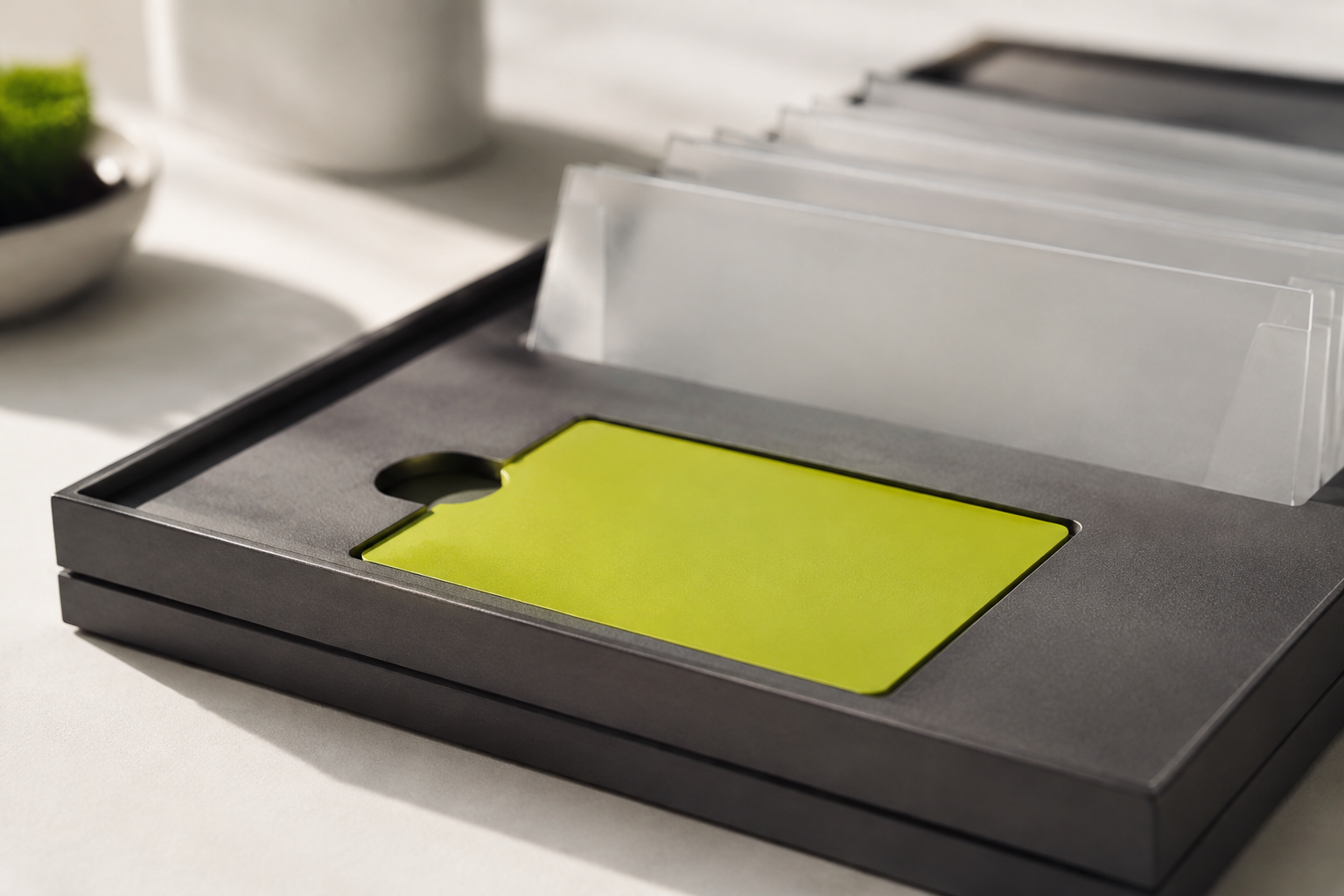 A lime starter card sits in a graphite tray beside frosted onboarding folders.